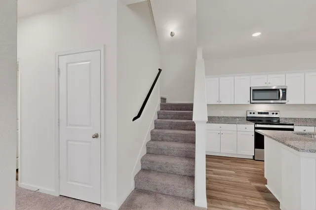 a kitchen with white cabinets and stainless steel appliances