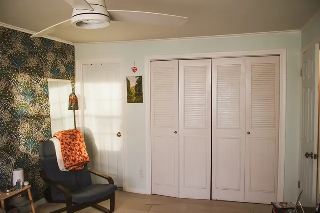 a view of a room with windows wooden table and chair