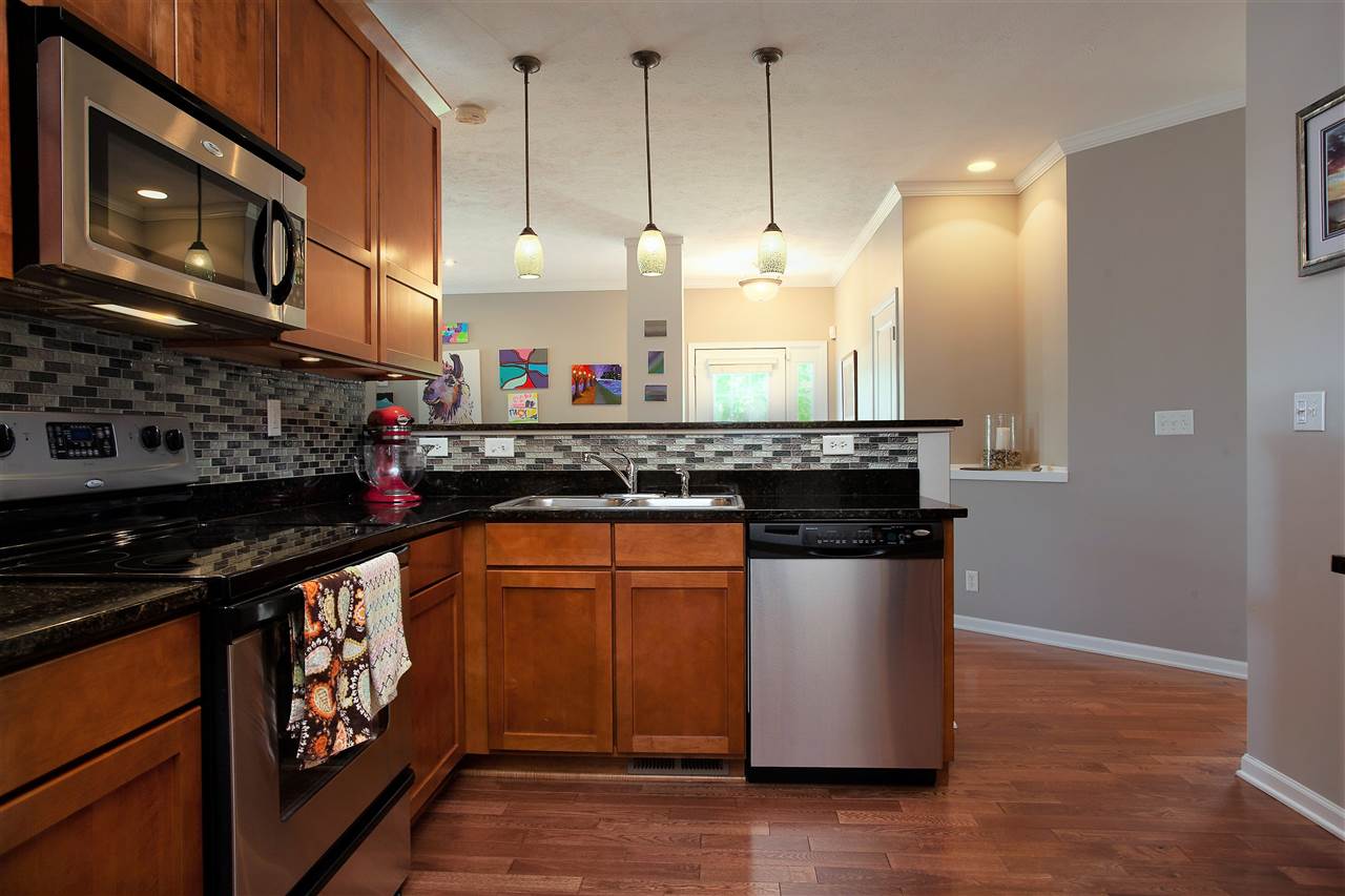 4403 Perry Ridge Lane Loves Park, IL 61111 - Photo 13 of 25 a kitchen with stainless steel appliances granite countertop a stove a sink and a microwave
