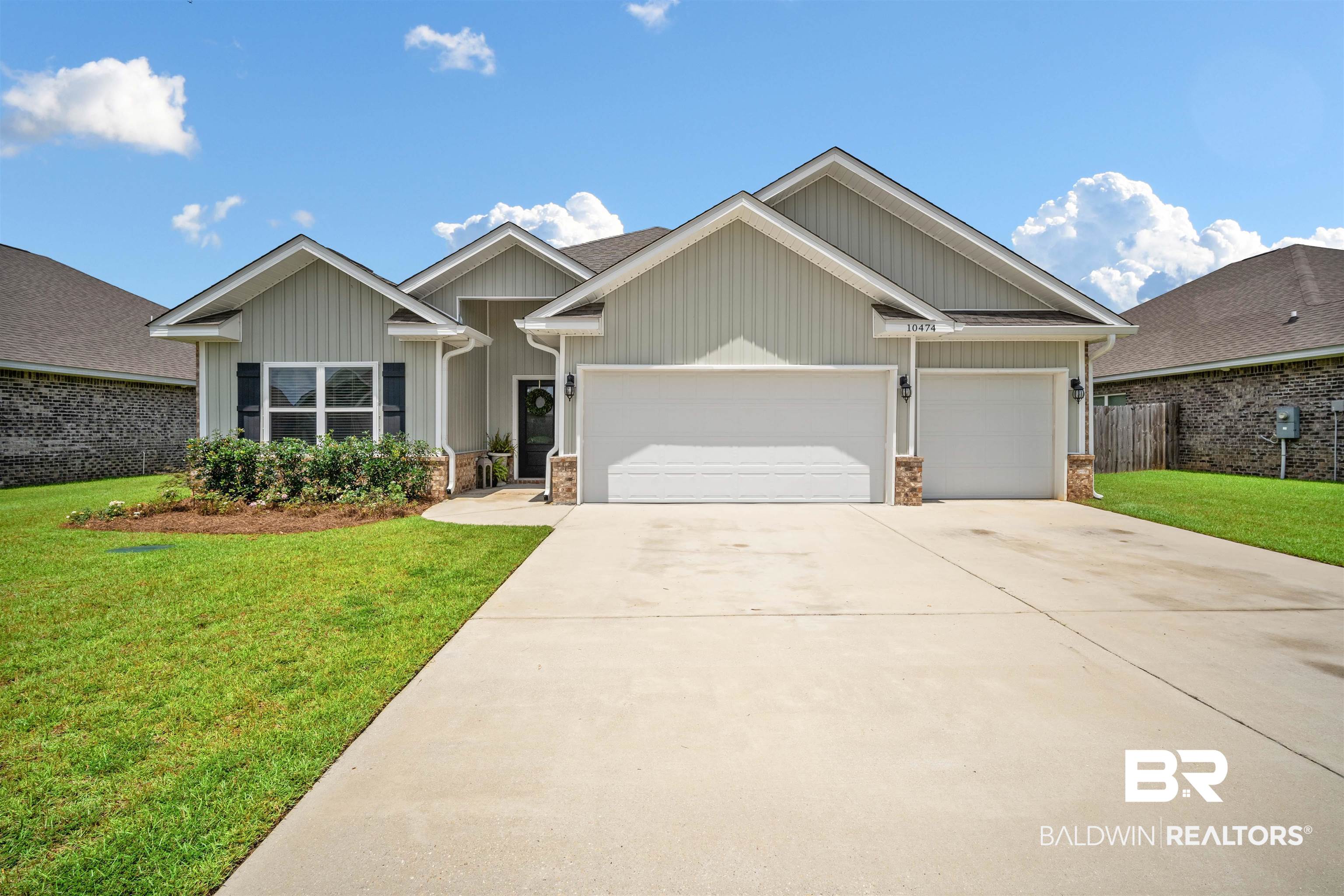 10474 Loamy Avenue Mobile, AL 36695 - Photo 1 of 31 View of front of property with a front yard, a garage, concrete driveway, and board and batten siding