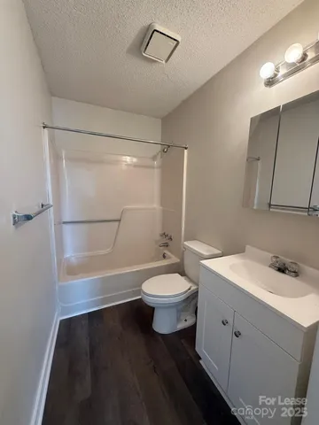 a bathroom with a sink a toilet a mirror and shower