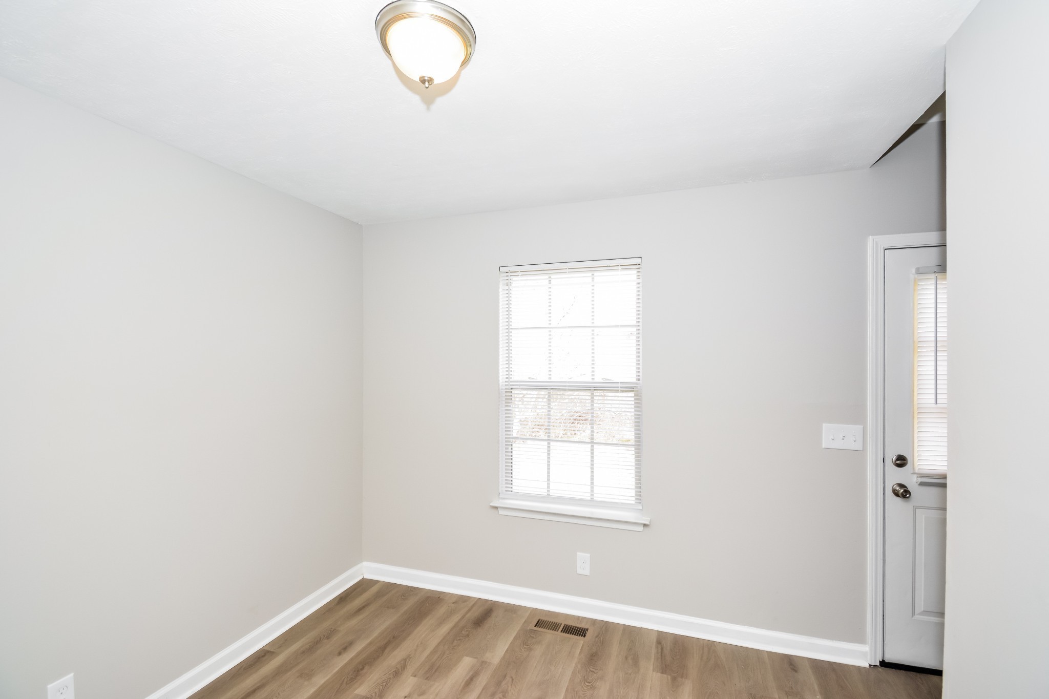 2607 Landrum Court, Unit 8 Springfield, TN 37172 - Photo 8 of 17 an empty room with wooden floor and windows