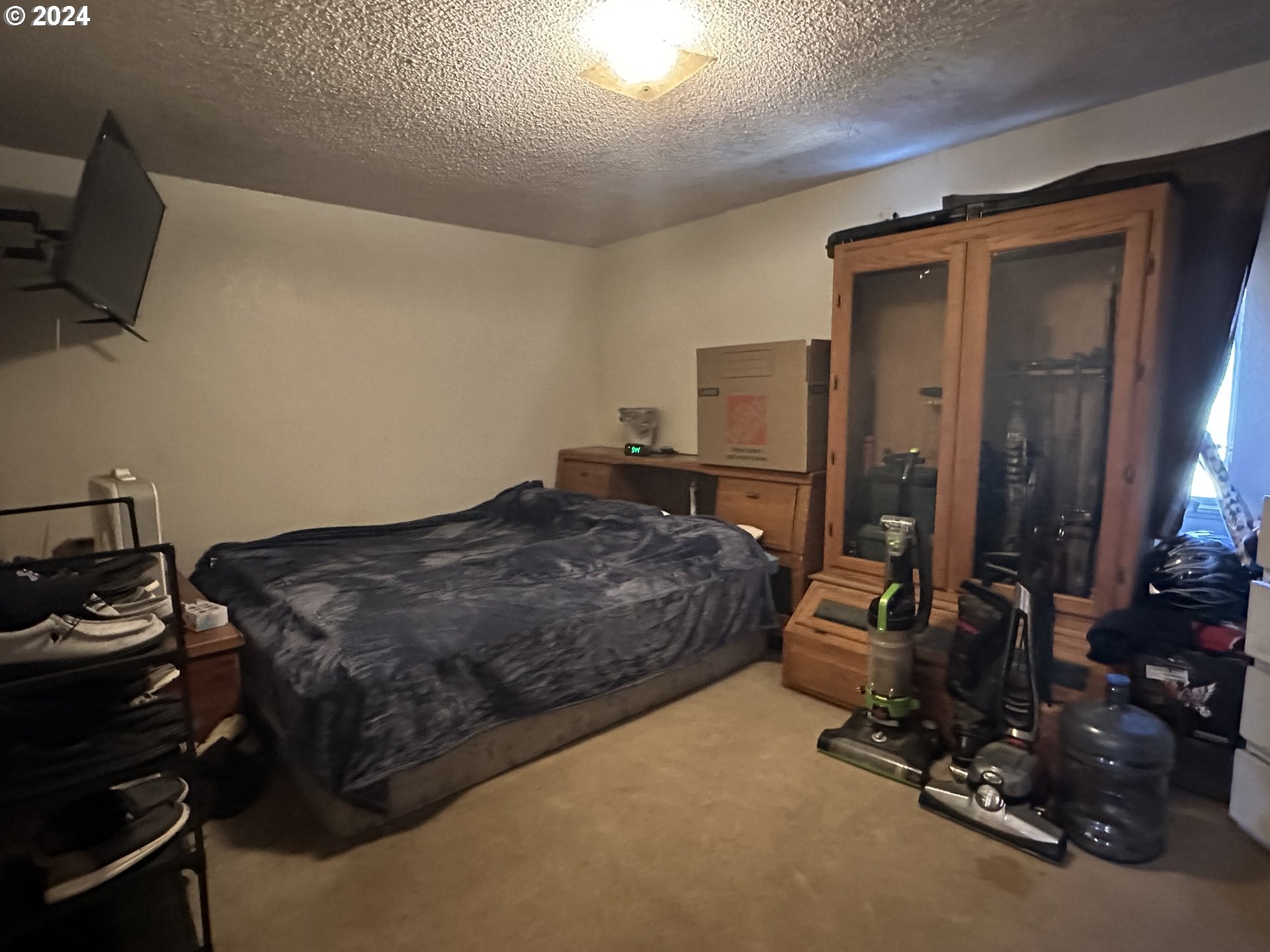 121 Copper Way Riddle, OR 97469 - Photo 8 of 21 a bedroom with a bed and a flat tv screen on the dresser