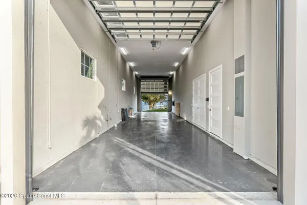 a large white kitchen with a large window a sink and stainless steel appliances