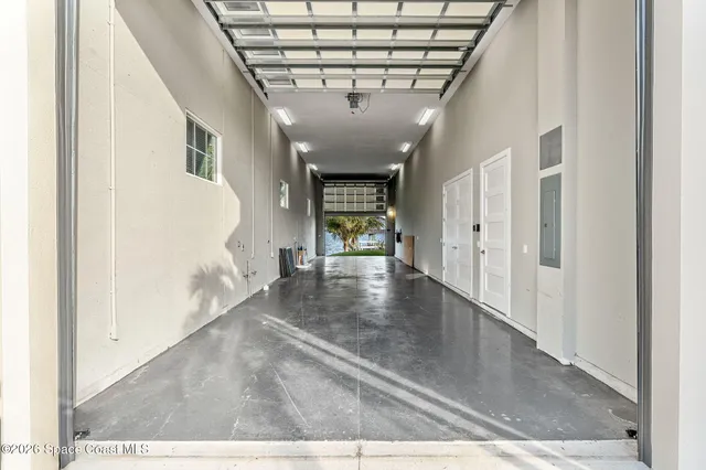 a large white kitchen with a large window a sink and stainless steel appliances