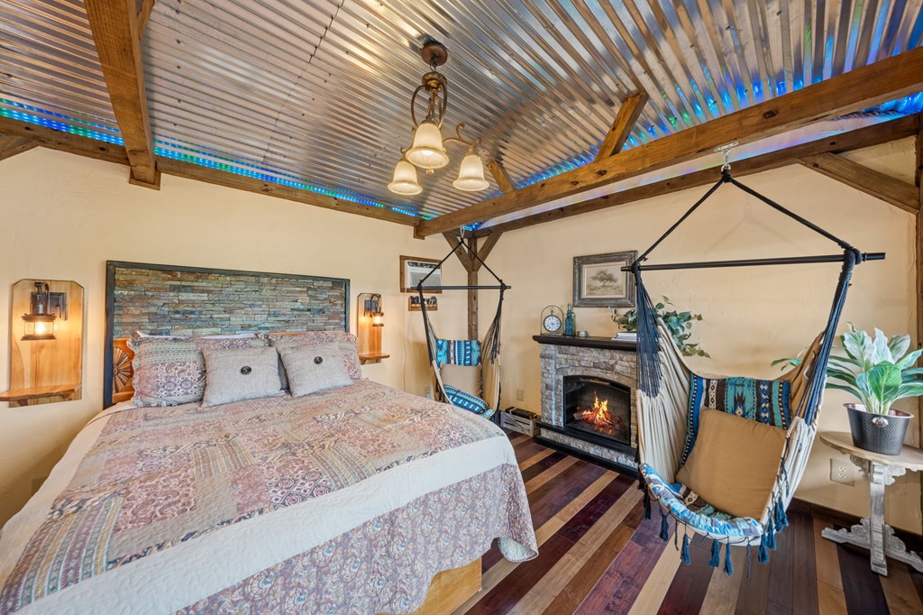 152 Henderson Branch Road West Ingram, TX 78025 - Photo 23 of 47 a bedroom with a bed a fireplace and a table