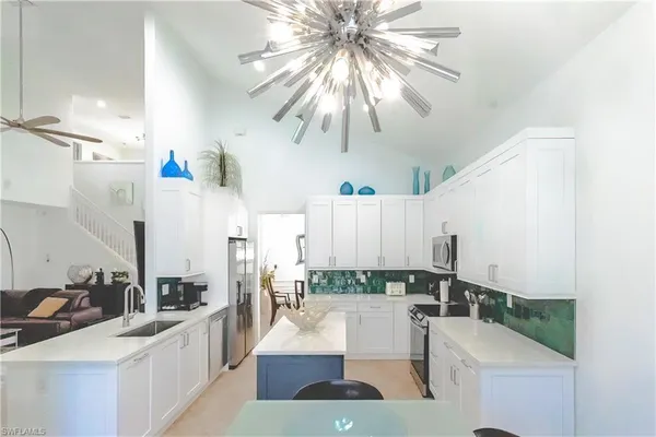 a kitchen with a sink a cabinets and chairs