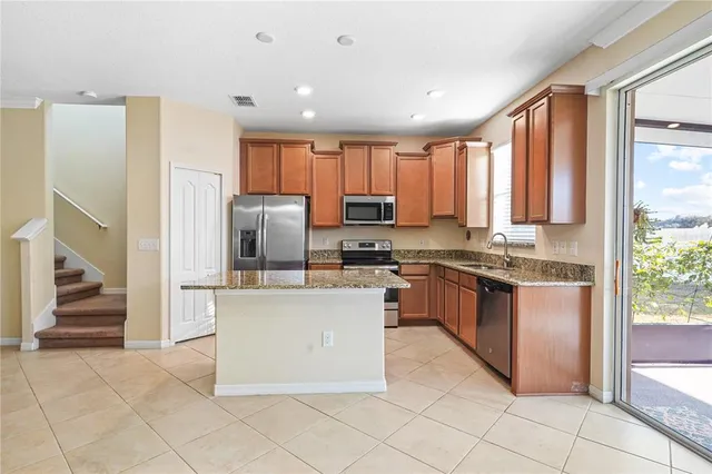 a kitchen with stainless steel appliances granite countertop a refrigerator oven a sink and dishwasher