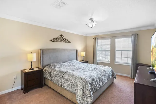 a bedroom with a large bed and a tv on dresser