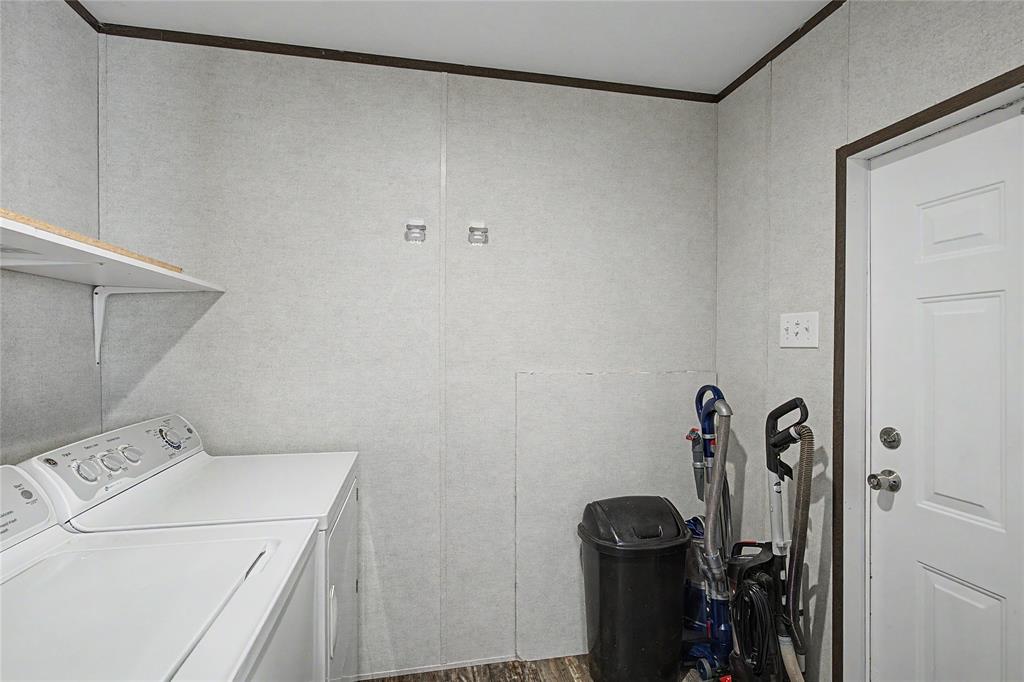 177 New Highland Road Springtown, TX 76082 - Photo 18 of 40 Dedicated laundry area with a white top-load washer and dryer, accompanied by a wall-mounted shelving unit