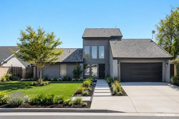 a front view of a house with a garden and garage