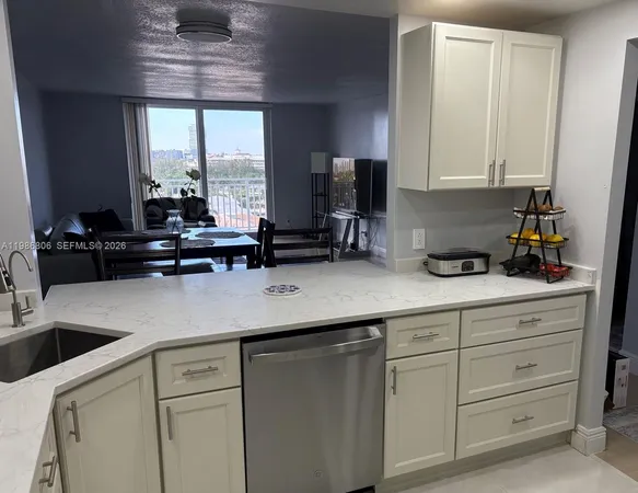 a kitchen with cabinets appliances a sink and a counter top space