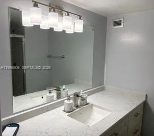 a bathroom with a sink vanity granite tub and shower