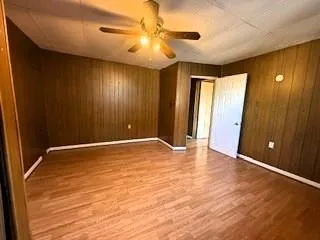 a view of an empty room with window and a ceiling fan