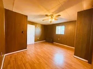 a view of an empty room with window and wooden floor
