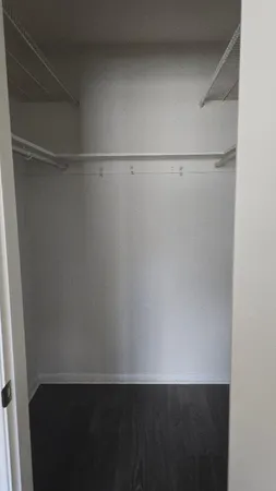 a view of a closet with wooden floor