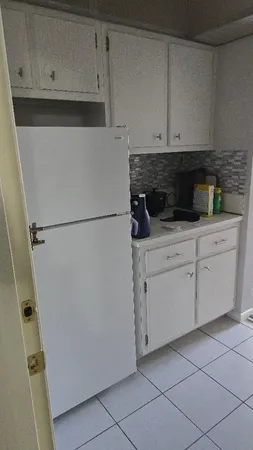 a kitchen with white cabinets and white appliances