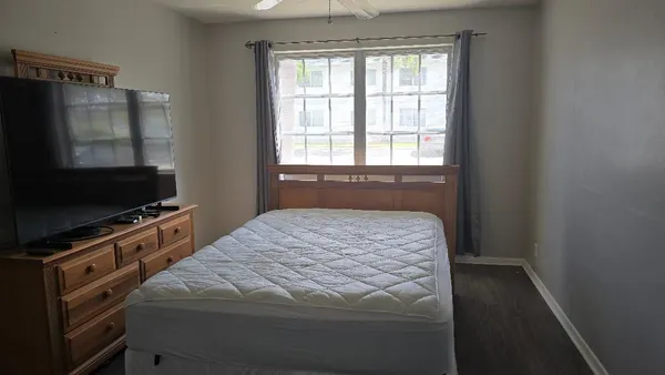 a bedroom with a bed and a flat tv screen in it