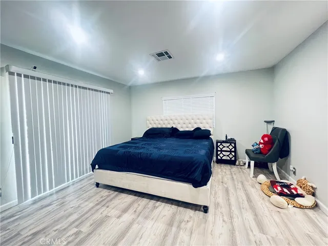 a room with a bed and a wooden floor