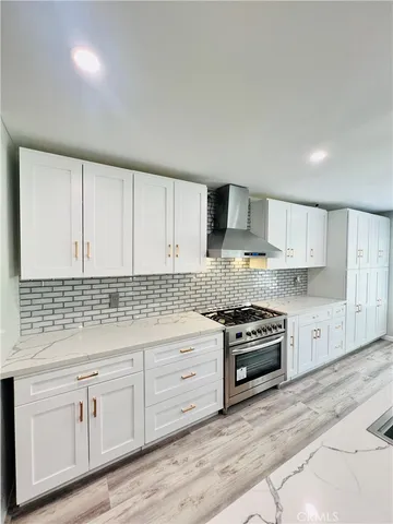 a kitchen with granite countertop white cabinets and stainless steel appliances