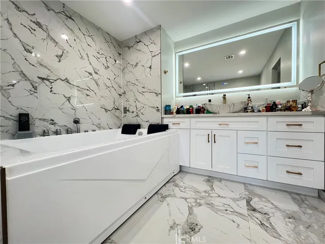 a bathroom with a bathtub sink and mirror