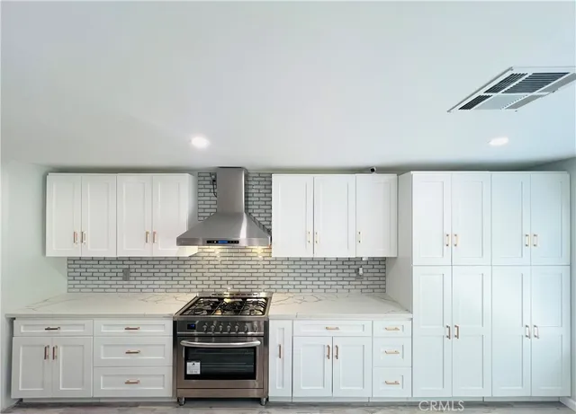 a kitchen with granite countertop white cabinets and stainless steel appliances