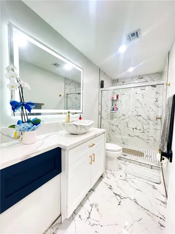 a bathroom with a sink vanity mirror and toilet