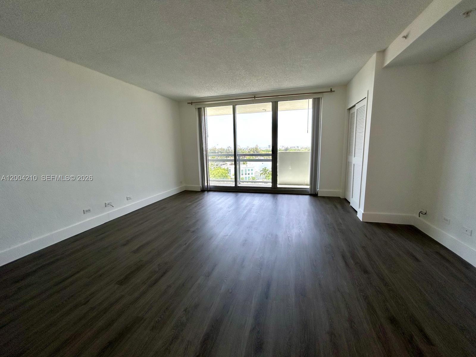 1500 Bay Road, Unit 1172S Miami Beach, FL 33139 - Photo 12 of 15 a view of an empty room with wooden floor and a window