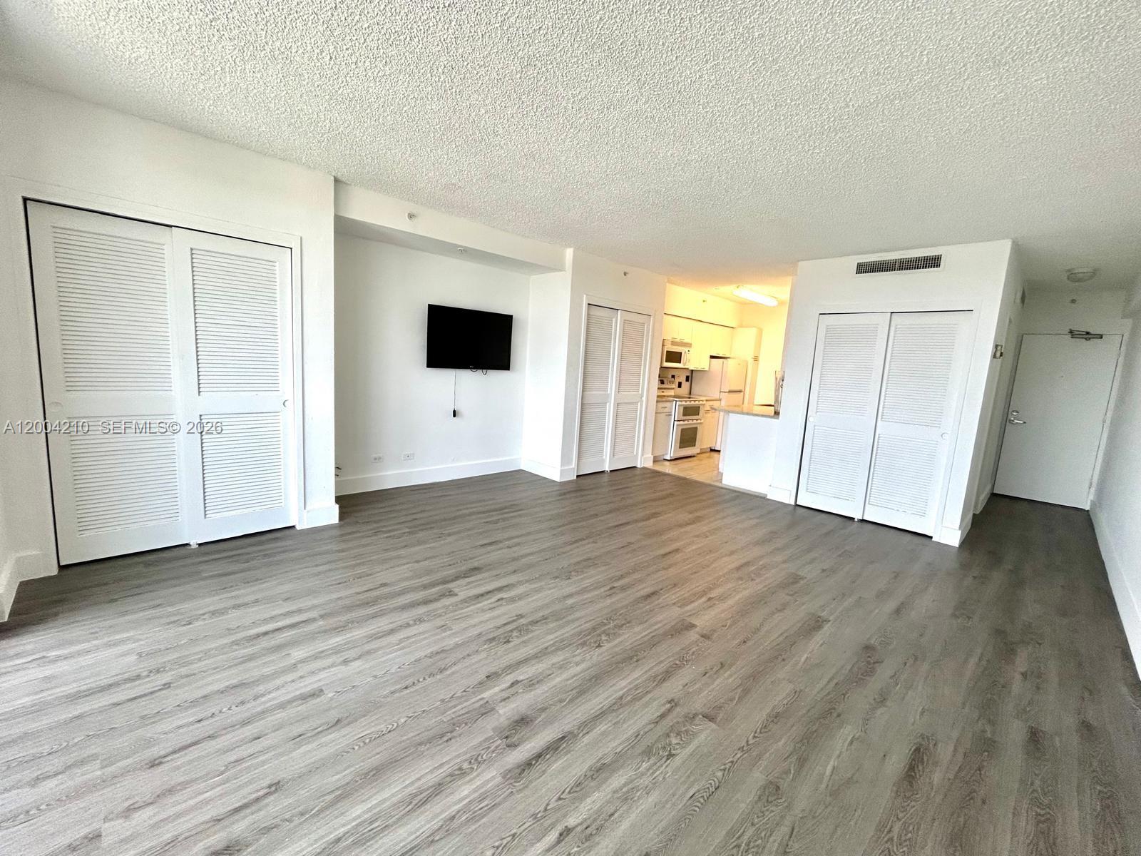 1500 Bay Road, Unit 1172S Miami Beach, FL 33139 - Photo 13 of 15 an empty room with wooden floor and windows