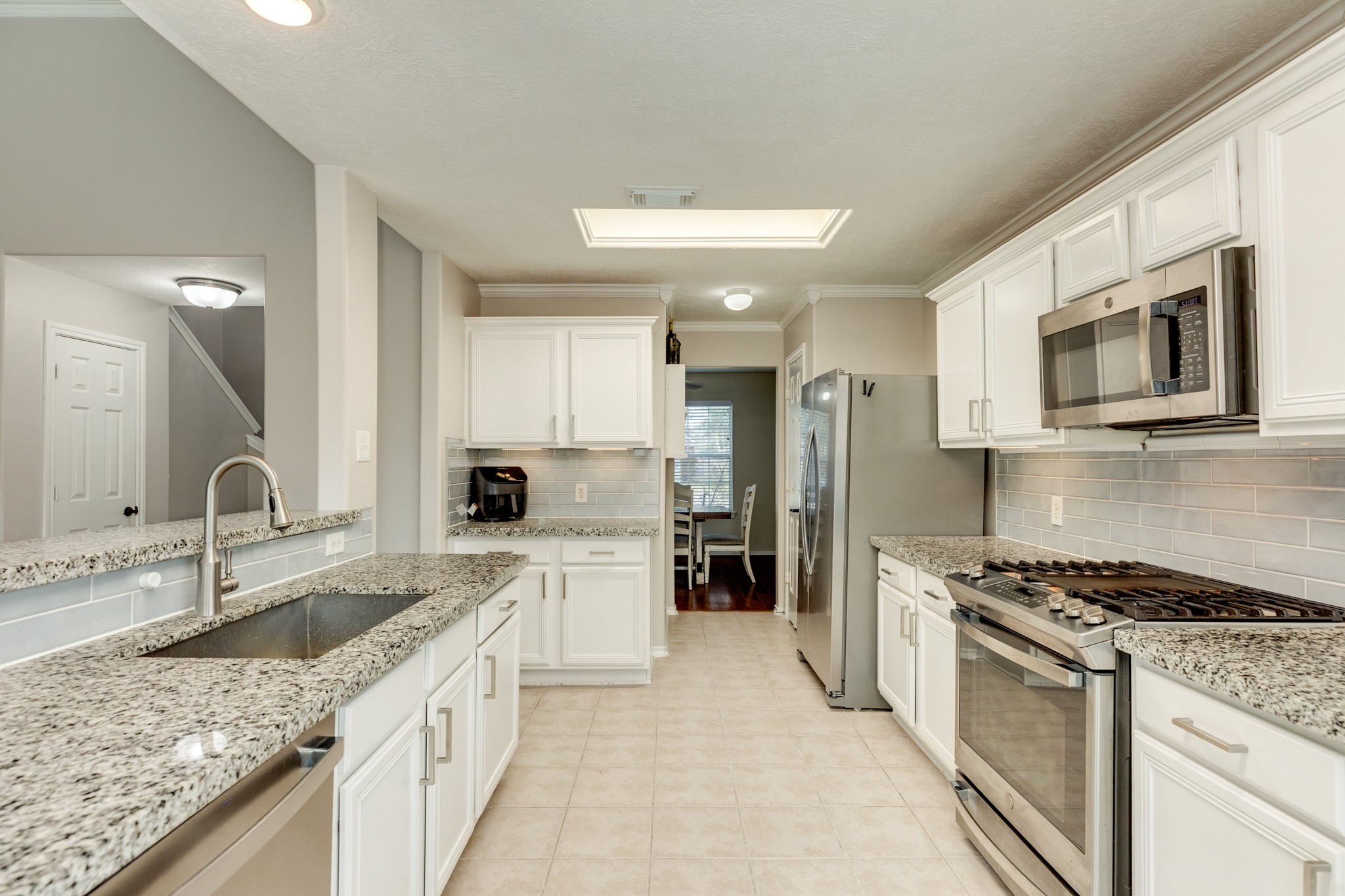 4113 Merlet Drive Pearland, TX 77584 - Photo 12 of 36 Kitchen features updated granite countertops, stainless steel appliances, new hardware, and fresh paint.