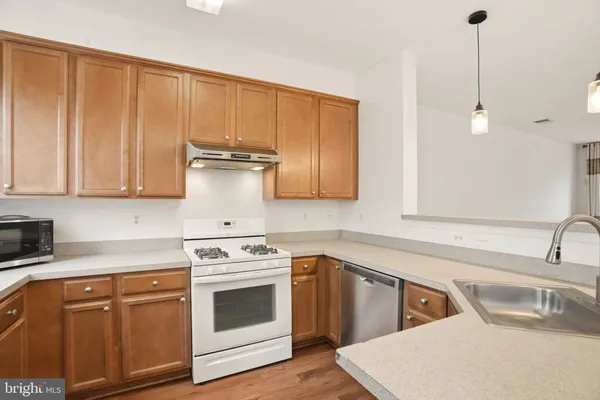 a kitchen with granite countertop a sink stainless steel appliances and cabinets