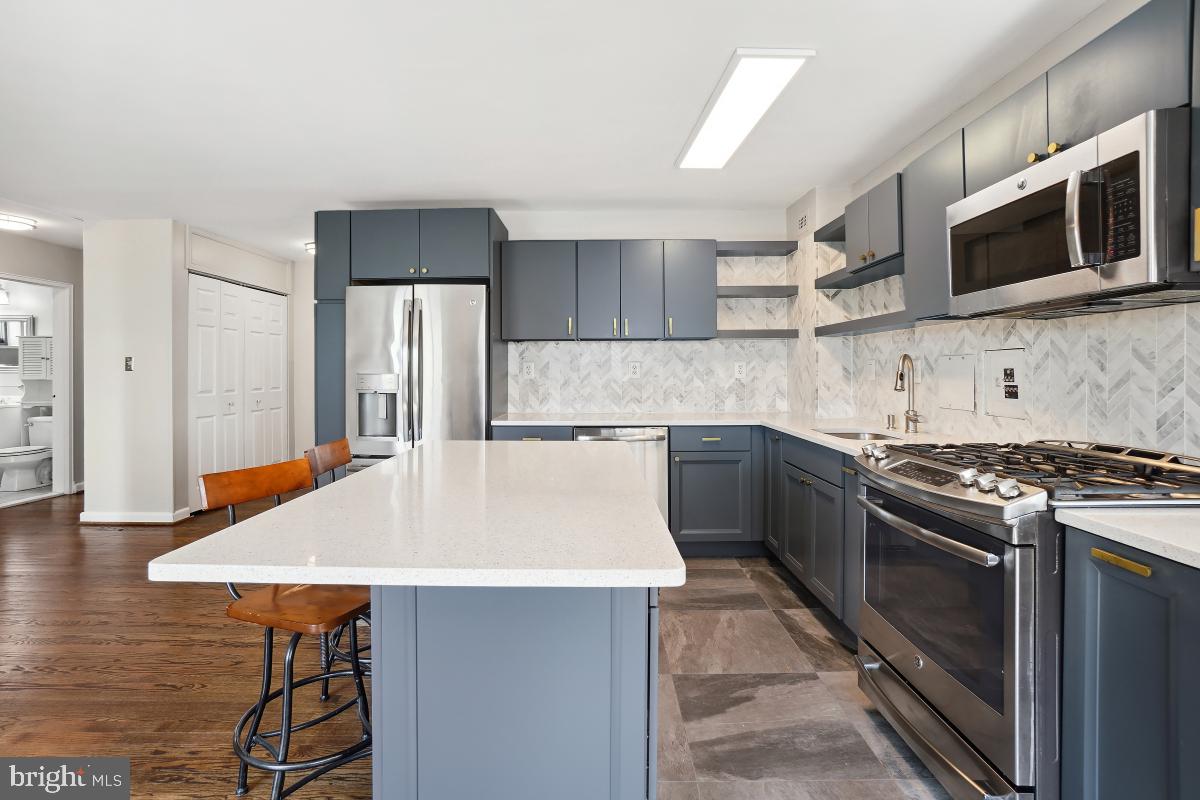 1200 South Arlington Ridge Road, Unit 618 Arlington, VA 22202 - Photo 5 of 17 a kitchen with stainless steel appliances a stove a sink and a microwave