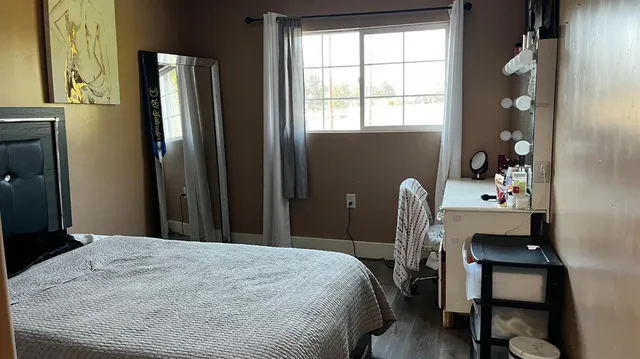 a bedroom with a bed and a desk next to a window