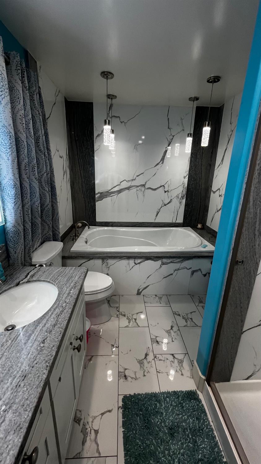 1738 U Street Rio Linda, CA 95673 - Photo 23 of 50 a bathroom with a granite countertop sink a toilet and a mirror