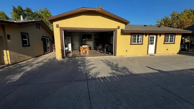 a kitchen with stainless steel appliances kitchen island granite countertop a refrigerator a stove and a wooden floors