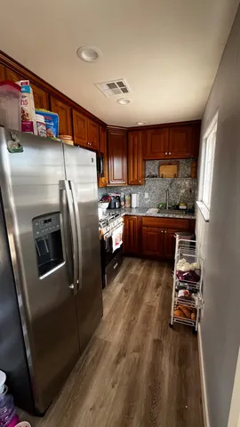 a room with stainless steel appliances a rug and a window
