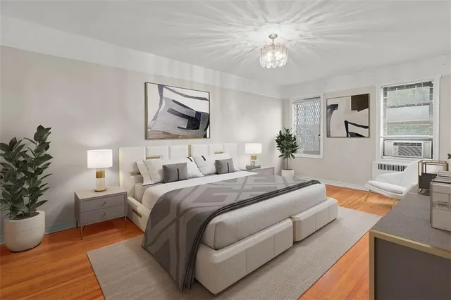 a bedroom with a large bed a potted plant and a window
