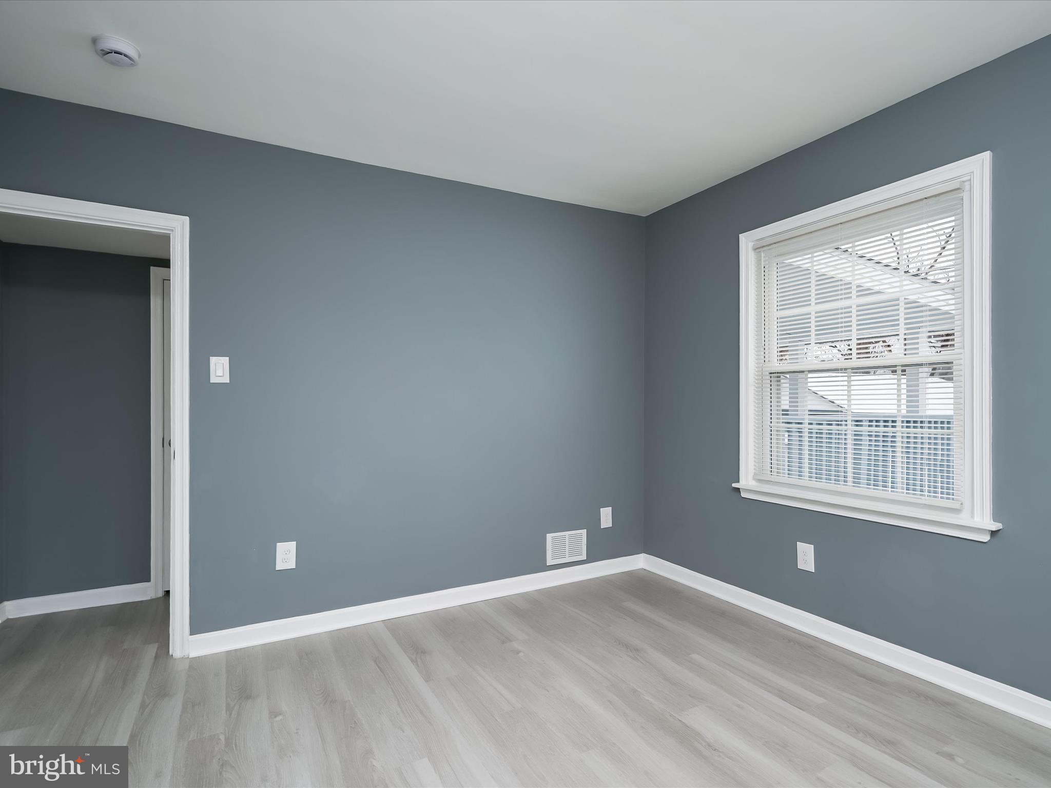 1709 Leslie Road Dundalk, MD 21222 - Photo 16 of 38 a view of an empty room with wooden floor and a window