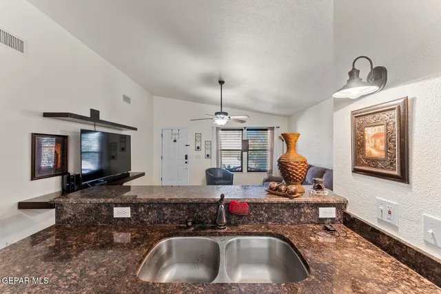 a kitchen with sink a stove and a wooden floor