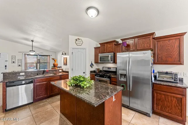 a kitchen with stainless steel appliances granite countertop a refrigerator a stove a sink and a refrigerator