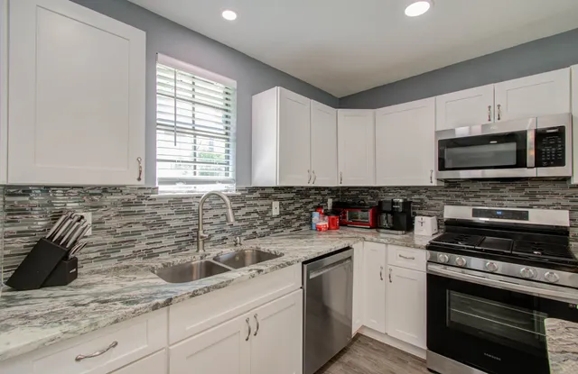 a kitchen with sink a microwave a stove and cabinets