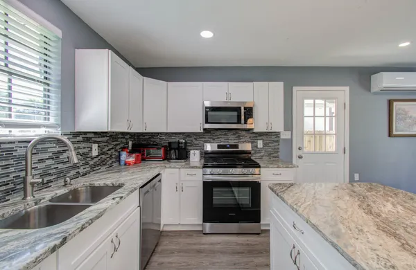 a kitchen with a sink stove top oven and refrigerator