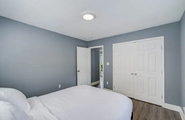a bedroom with a bed and wooden floor