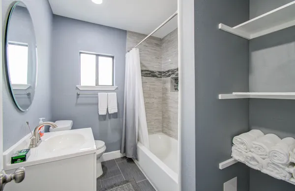 a bathroom with a sink a toilet and shower