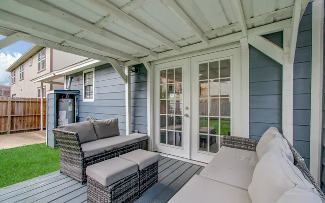 a view of a patio with couches and a dining table with garden view