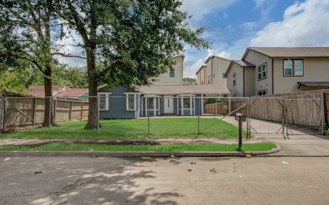 a front view of a house with a garden and trees