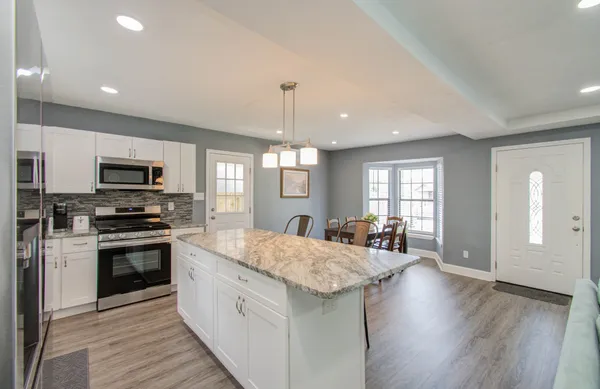 a large kitchen with sink a refrigerator and microwave