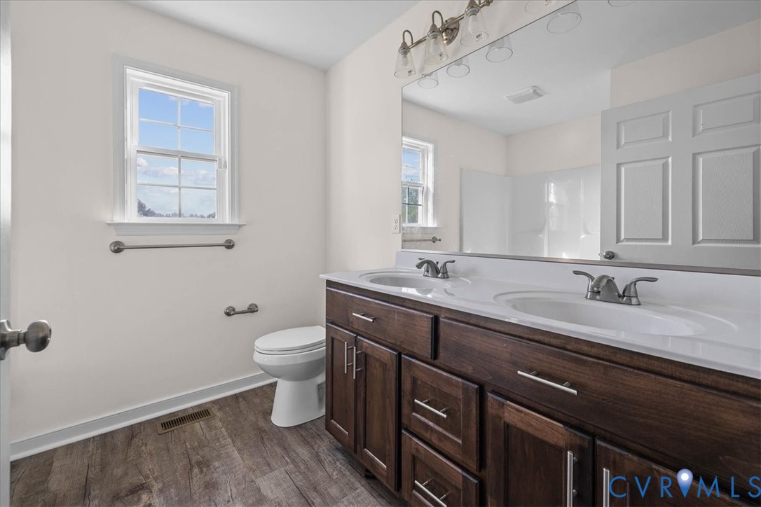 11325 Webb Road Disputanta, VA 23842 - Photo 14 of 32 a bathroom with a granite countertop sink a toilet and a mirror