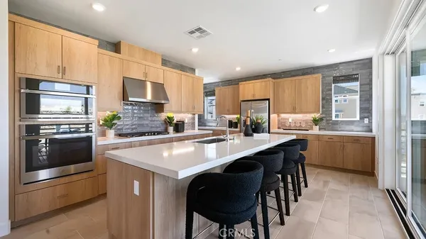 a kitchen with stainless steel appliances granite countertop a stove a sink a microwave a refrigerator and cabinets