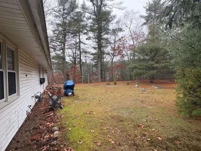 a backyard of a house with table and chairs